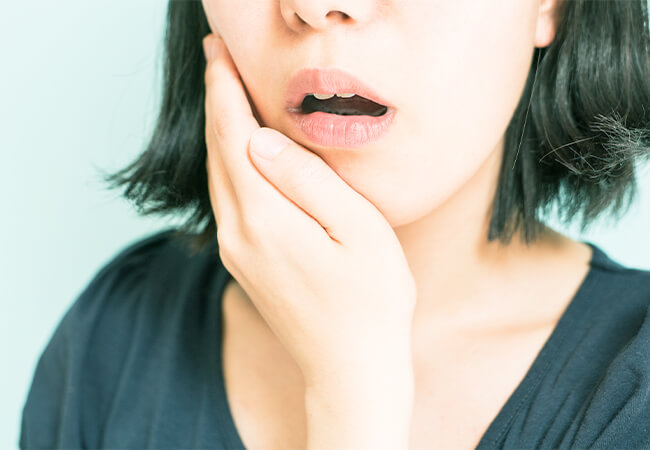 歯を抑える女性